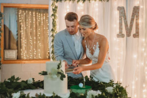 Bride and Groom are cutting their cake in a grand island wedding venue.