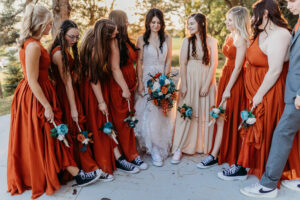 bride with her bridesmaids showing off their shoes and flowers
