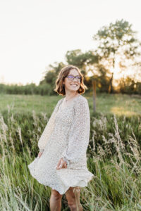 senior girl wearing a dress in a field from a nebraska boutique